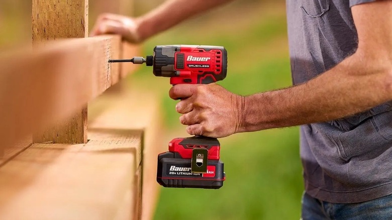 Person using an impact driver while building  a deck