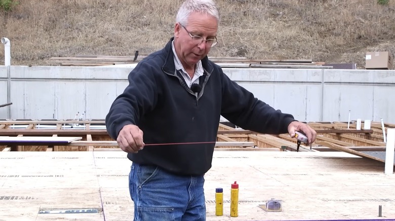 Man using a chalk line while building a deck