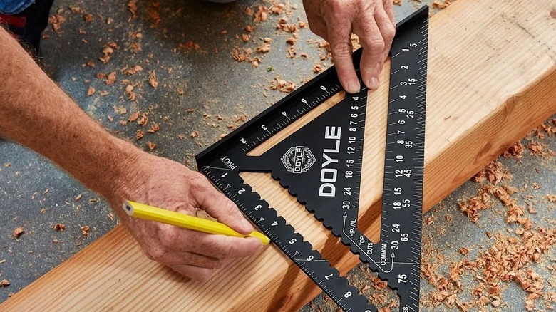 Person using a speed square to mark a board