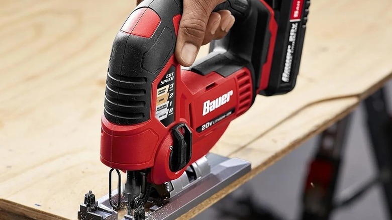 Person cutting plywood with a jigsaw