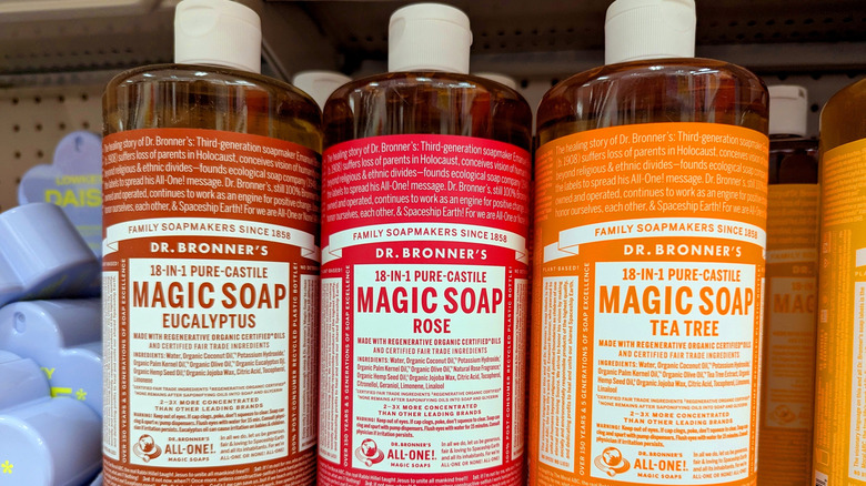 Bottles of castile soap with different essential oils on a store shelf.