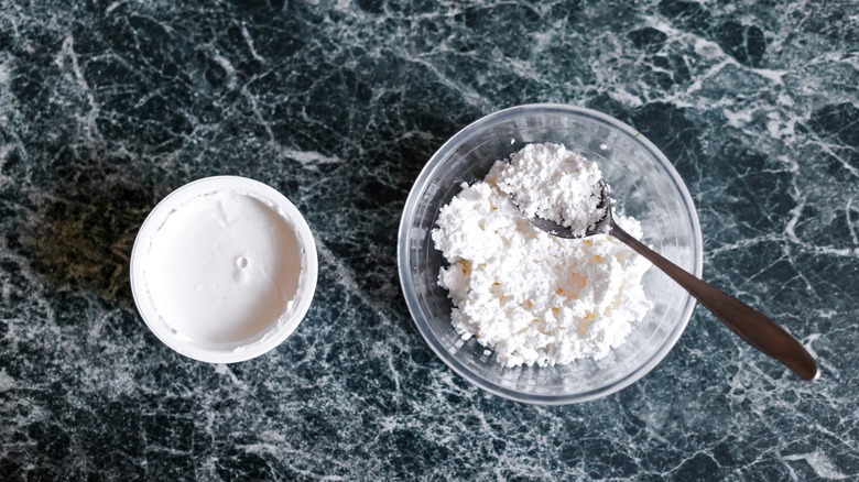 A bowl of cream of tartar on a marble surface.