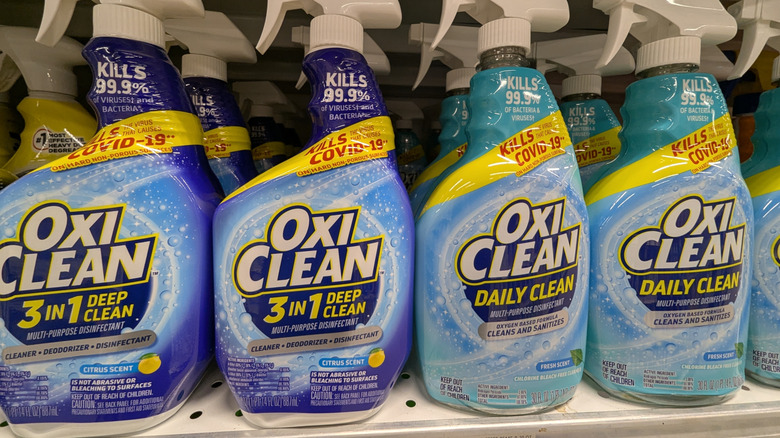 Bottles of different Oxi Clean products on a store shelf.