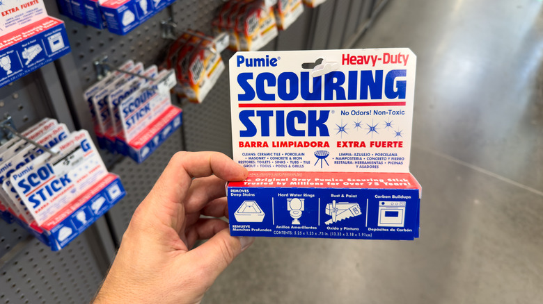 A hand holding a pumice scouring stick in the store.