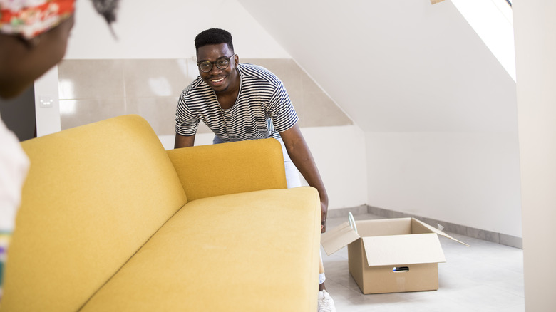 couple moving yellow sofa