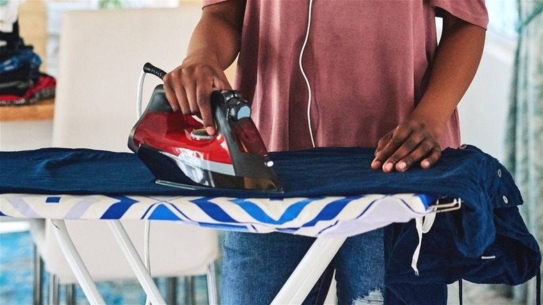 person ironing clothes on board