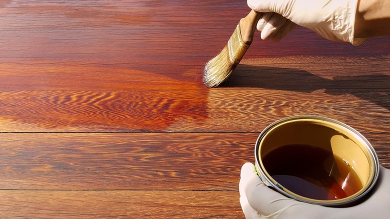 Person brushing wooden floor with oil