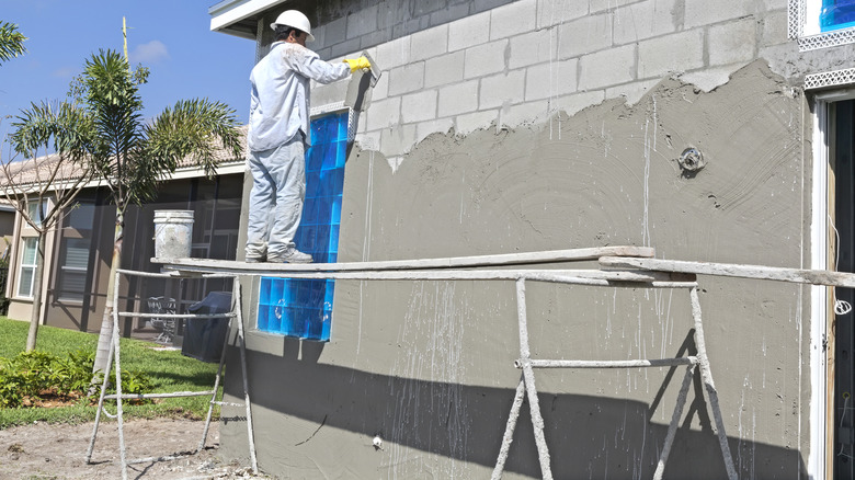 Contractor applying stucco to wall