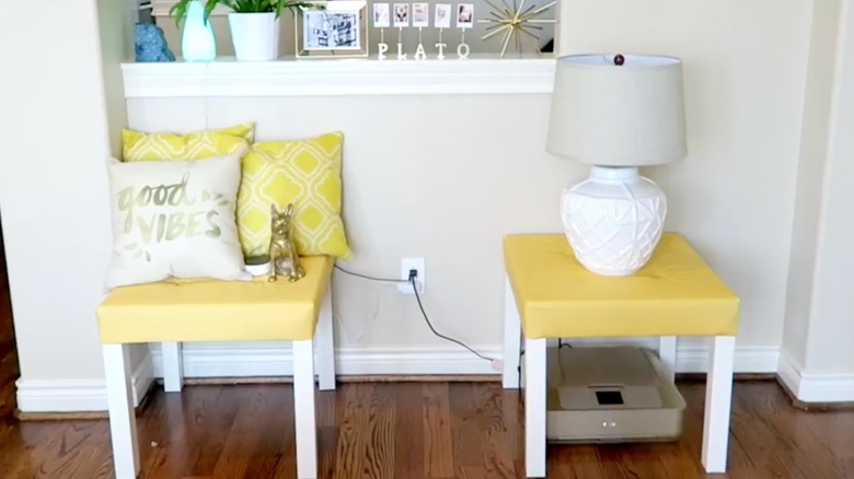 Yellow upholstered tables with cushions and a lamp on top