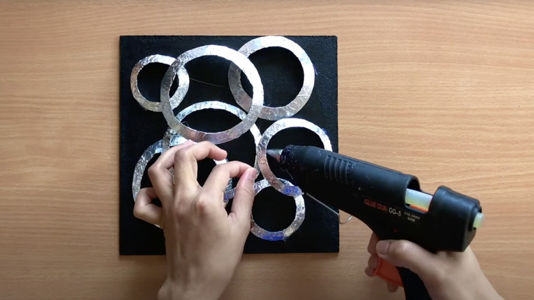 woman making aluminum foil wall decor