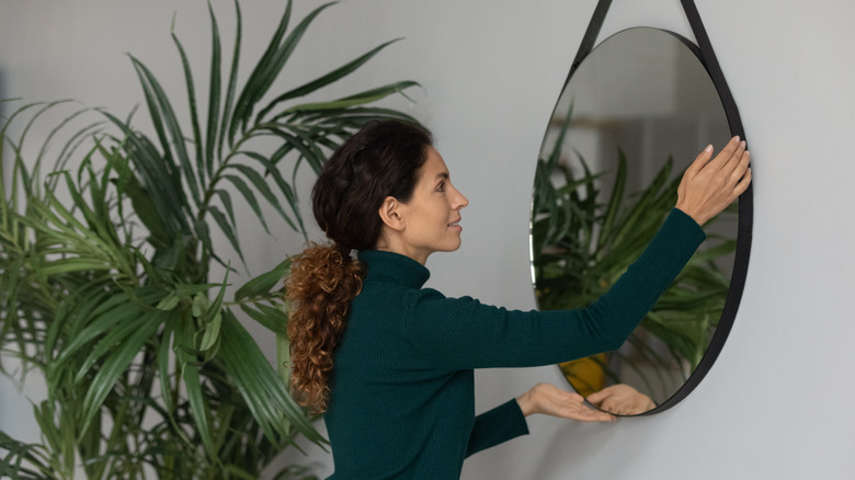 woman hanging mirror