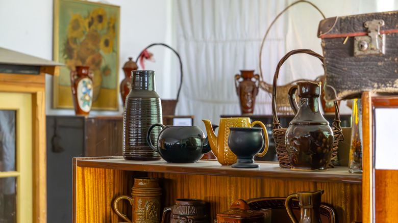 Collection of vintage pottery pieces on shelves.
