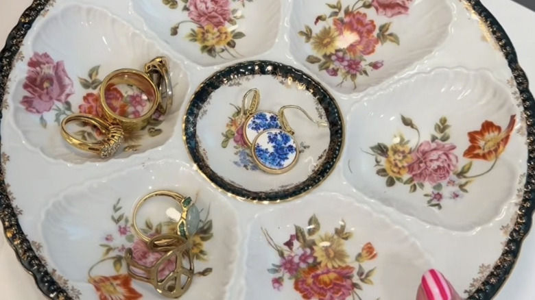 A vintage oyster plate being used as a trinket plate for jewelry