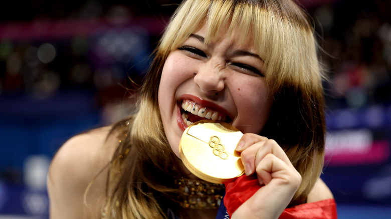 Alysa Liu bites her Olympic gold medal.