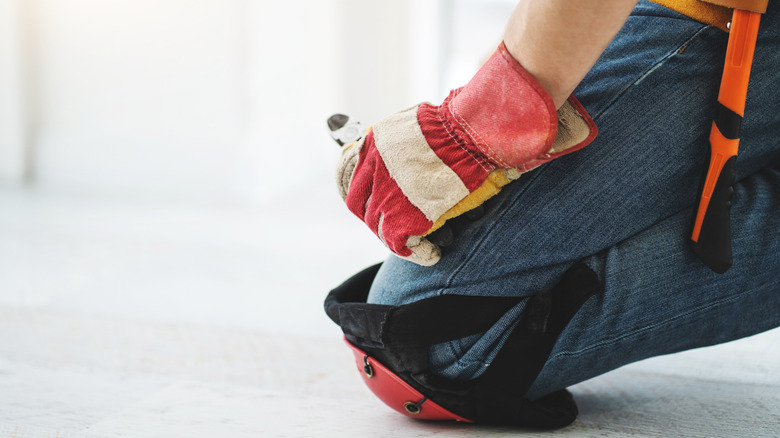 Man on job site wearing knee pads