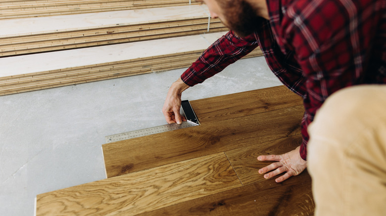 Man measuring vinyl floor installation