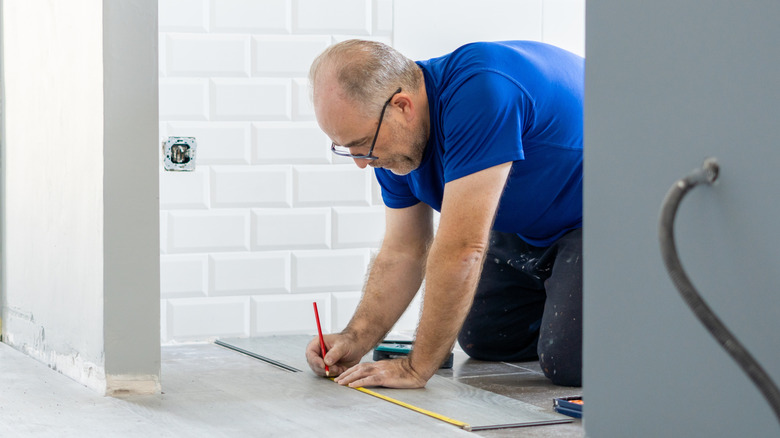 Man marking vinyl planks