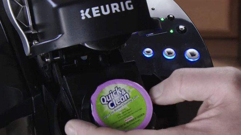 Person inserting a Quick & Clean K-Cup in a coffee maker