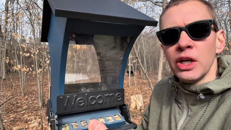 Man holding the Wildpark squirrel-proof feeder outside