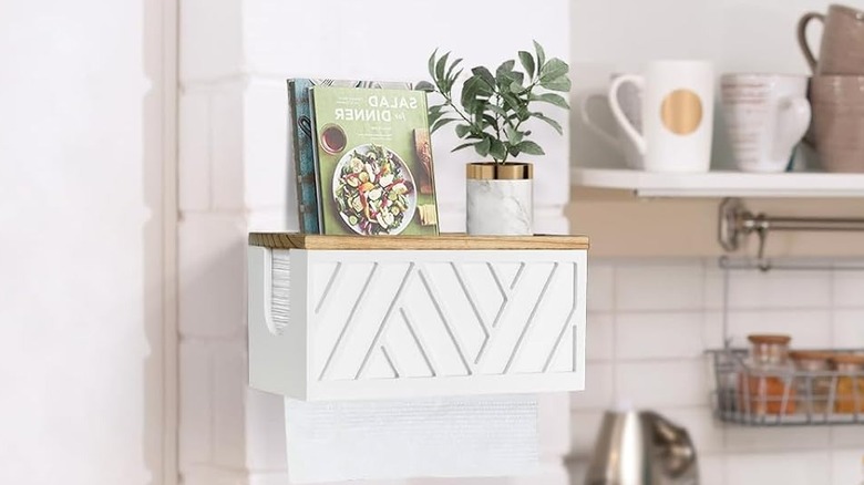 A wooden paper towel holder box mounted on a wall
