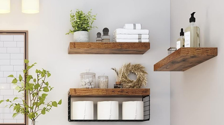 Wooden shelves with toilet paper and other amenities in a bathroom