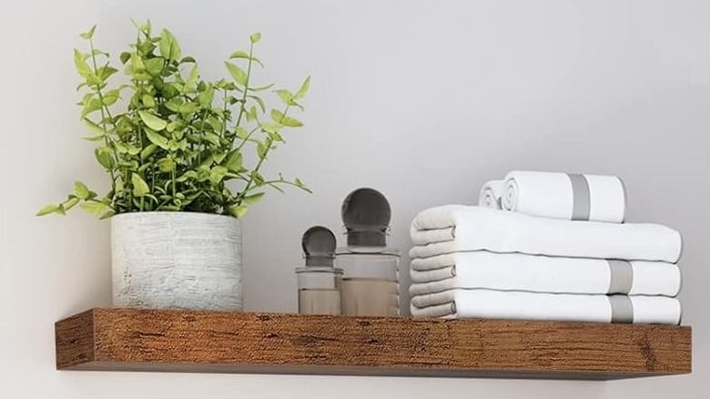 A shelf with folded towels in a bathroom