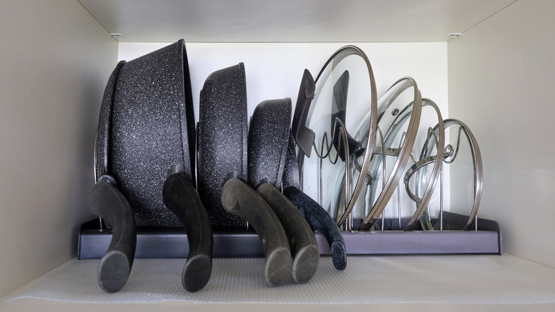 Pans and lids organized inside a cabinet
