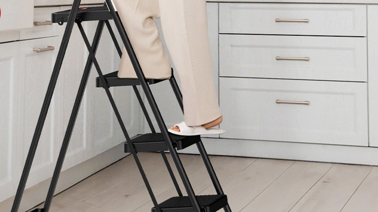 Woman's feet on a black step ladder