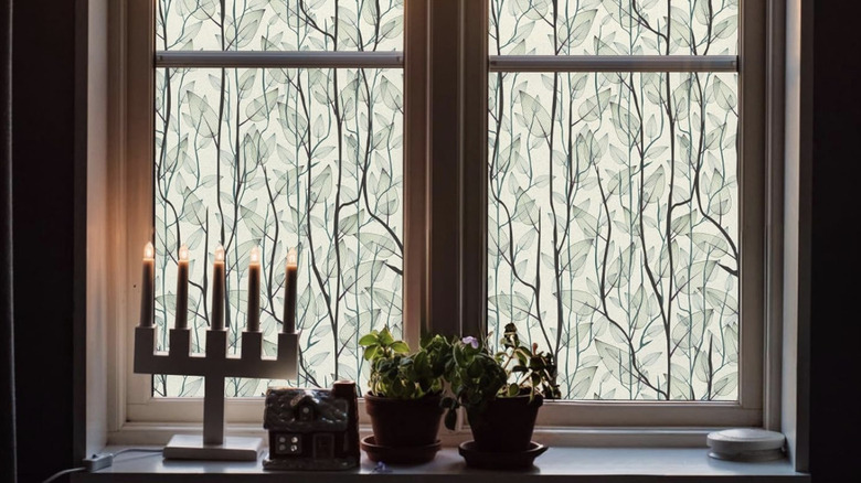 Leaves and branches window cling on double-hung windows with decor on sill