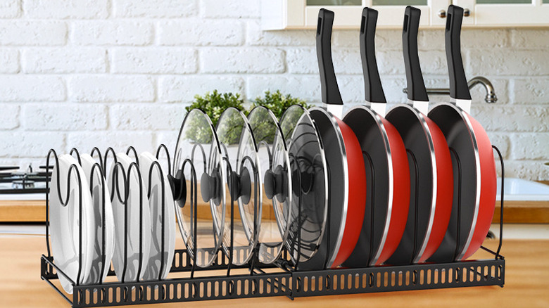A black pan and pot organizer holding pans and lids