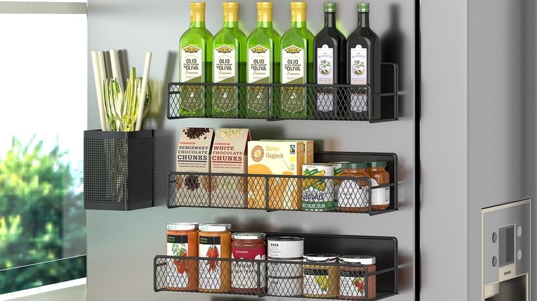 Black mesh magnetic racks over a silver fridge holding kitchen items