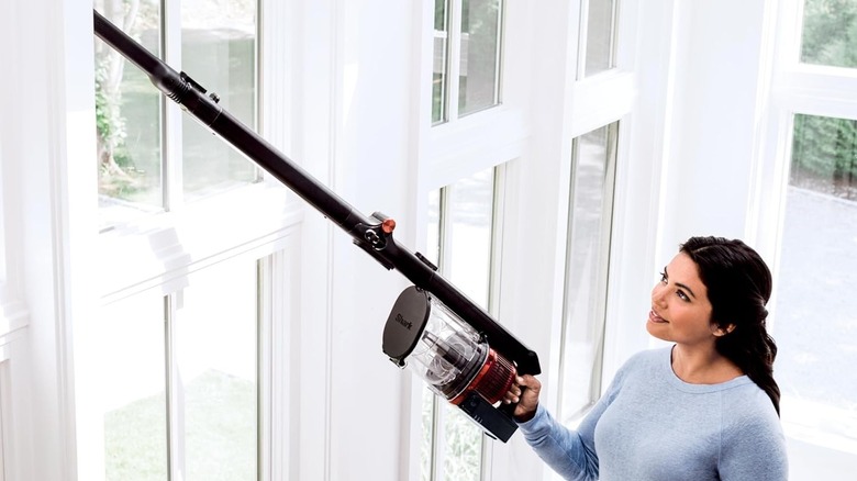 Woman using the Shark vacuum on curtains