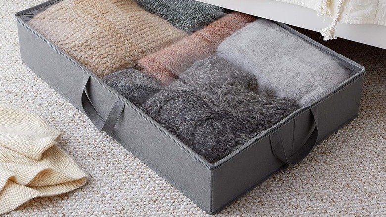An Amazon Basics Under Bed Storage Bag filled with clothes