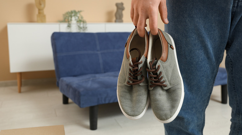 Man holding a pair of shoes