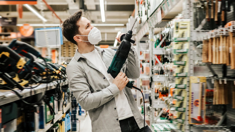Man holding a power drill in a store