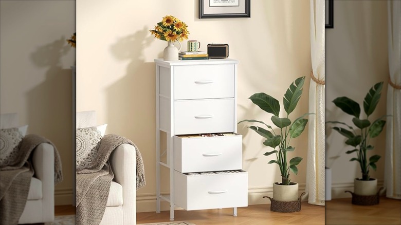 The Sweetcrispy four drawer dresser in a living room with flowers and books styled on top.