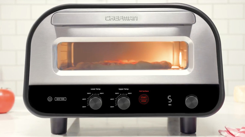 A Chefman pizza oven on a countertop in a white kitchen