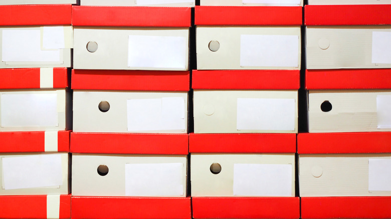 Multiple white shoeboxes with red lids stacked on top of each other