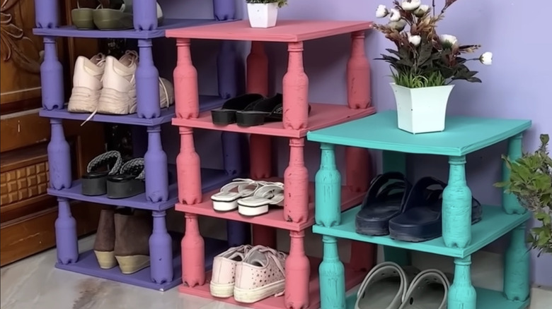 Three shoe racks in purple, pink, and blue made from empty plastic bottles