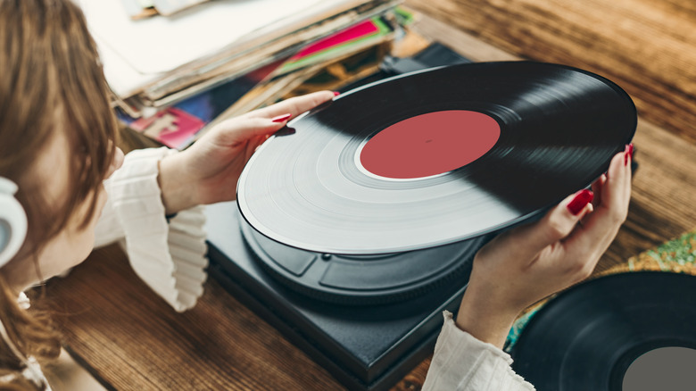 Woman with headphones holding vinyl record