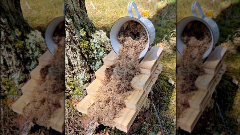 Mug with craft moss spilling out onto mini wood pallets