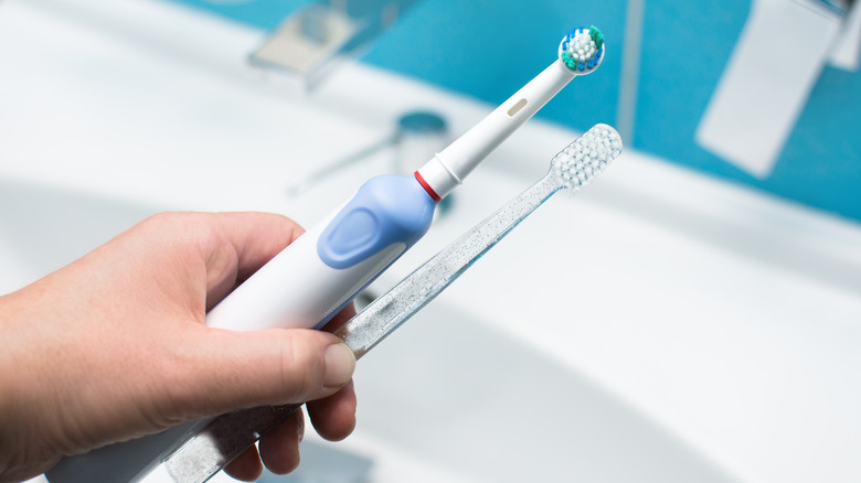 person holding electric toothbrush