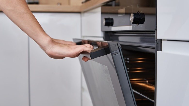 person opening oven door