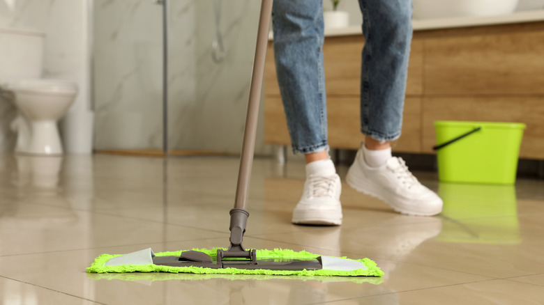 Person pushing green mop