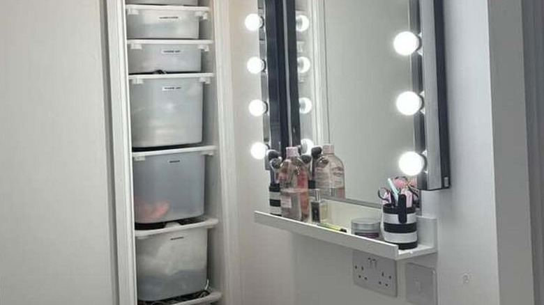 Vanity made with a wall-mounted mirror with bright bulbs and two picture ledge shelves
