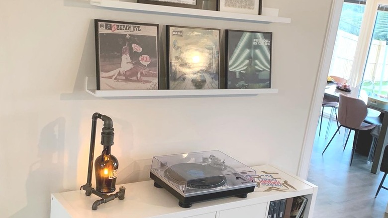 White IKEA  shelves holding up three records, including Oasis