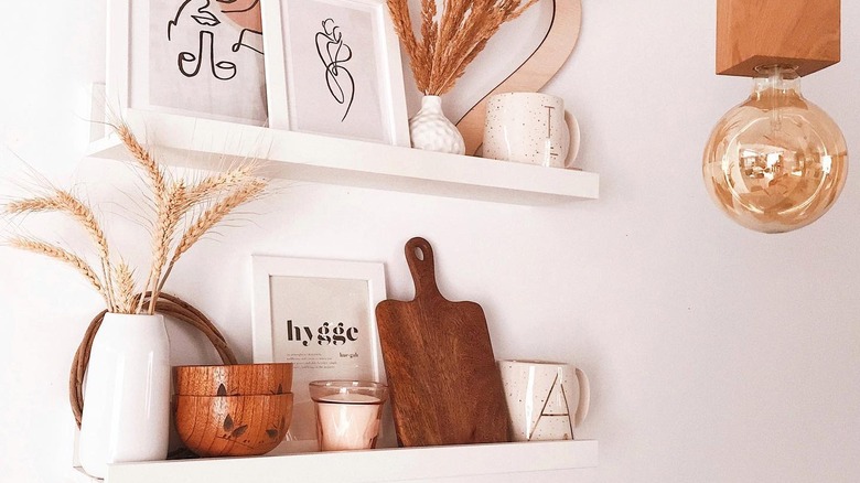 Picture ledge used to store small wooden bowls, a candle, cutting board, and plant