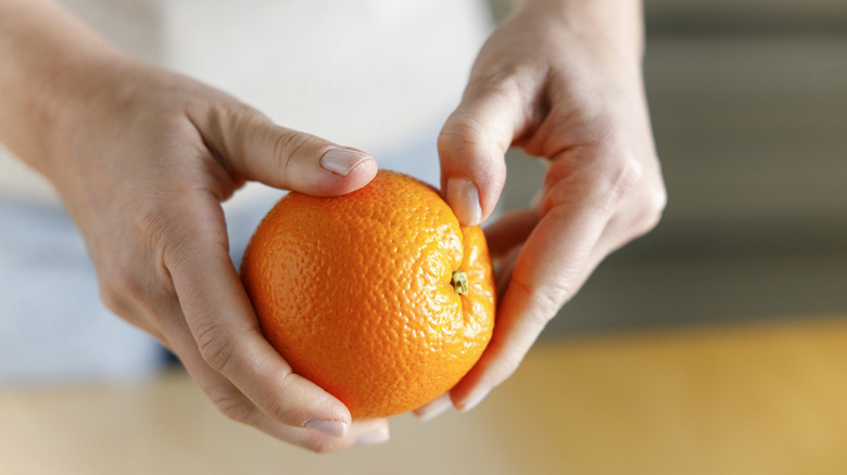 woman peels orange