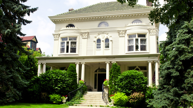 The entrance to a historic home, with lots of character including grand stairs, molding, and lots of small details.
