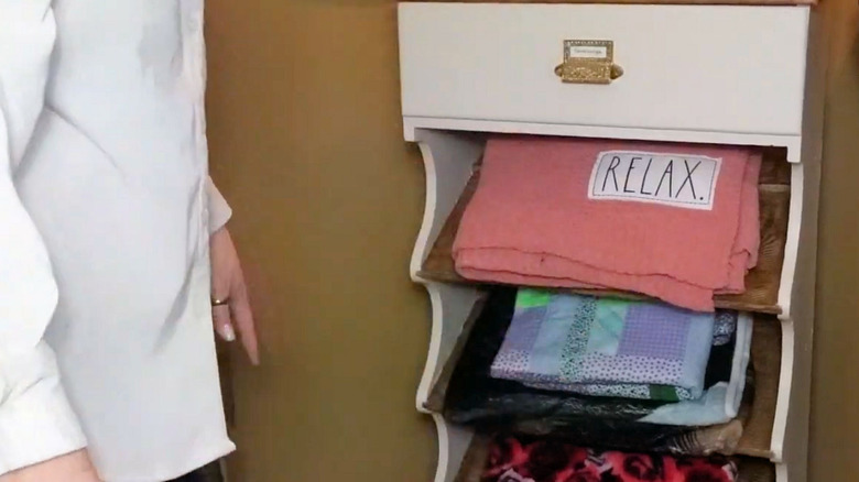 A shoe rack turned into blanket storage.